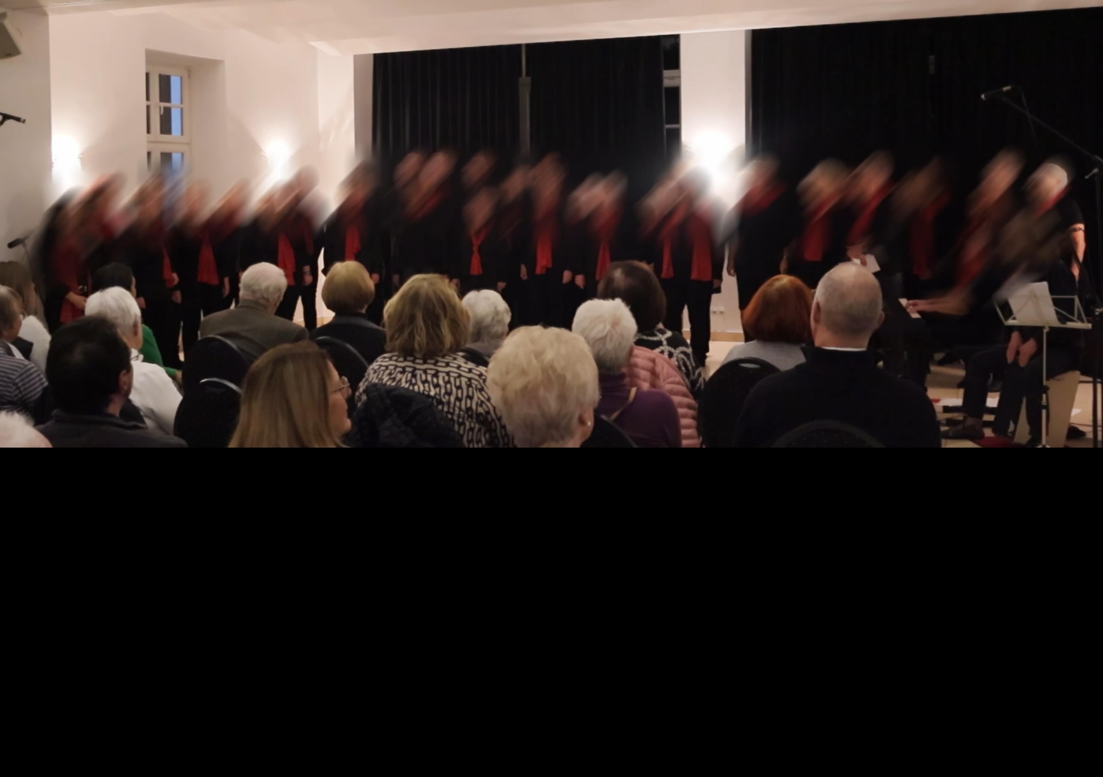 Weiterer Chorauftritt von No Limits im Saal, Gruppe in Schwarz mit roten Akzenten